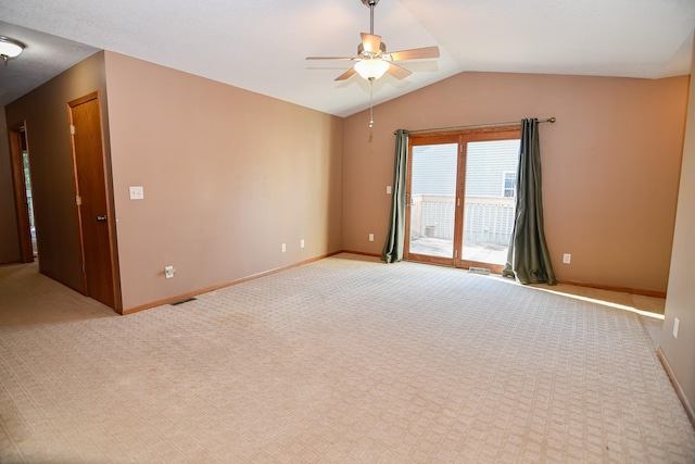 carpeted spare room featuring vaulted ceiling and ceiling fan