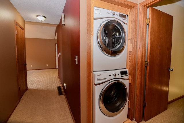 laundry room with light carpet and stacked washer and clothes dryer