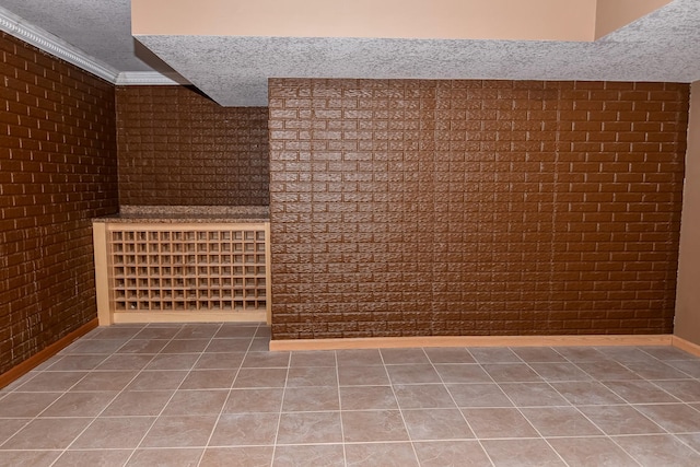 bonus room featuring tile patterned floors, brick wall, and a textured ceiling