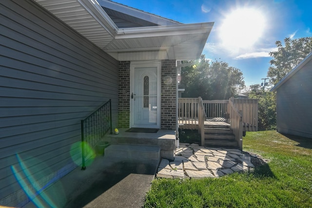 view of exterior entry featuring a yard