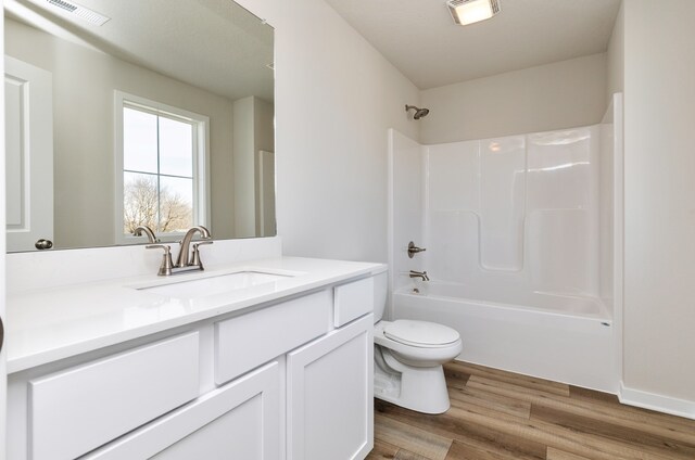 full bathroom with hardwood / wood-style floors,  shower combination, vanity, and toilet