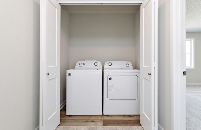 173 NE 56th St, Pleasant Hill, IA 50327 - laundry room featuring washing machine and dryer, wood finished floors, and baseboards
