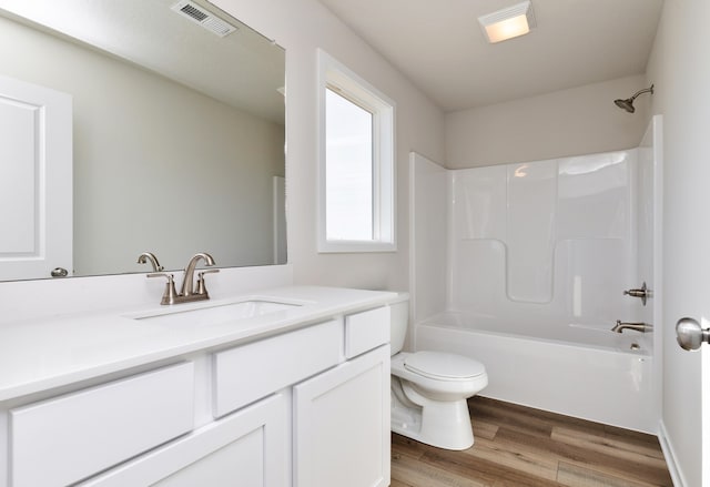 full bathroom with wood-type flooring, shower / bathing tub combination, vanity, and toilet