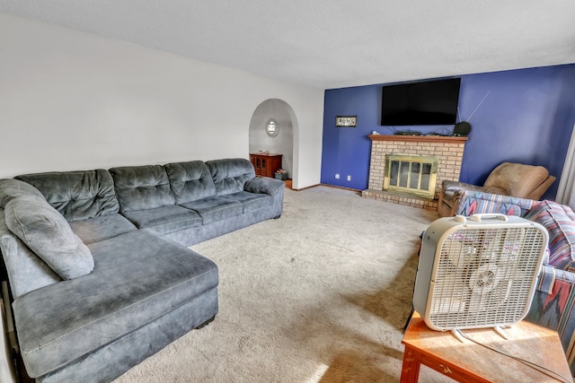 carpeted living room featuring a textured ceiling and a fireplace