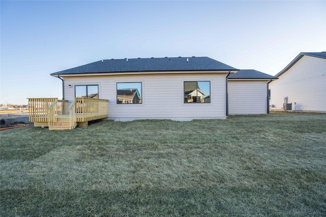 back of house featuring a lawn, a deck, and central air condition unit