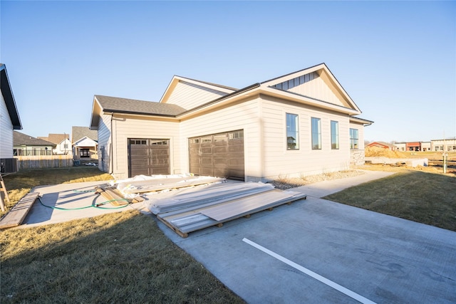 exterior space with a front yard, a garage, and central AC unit