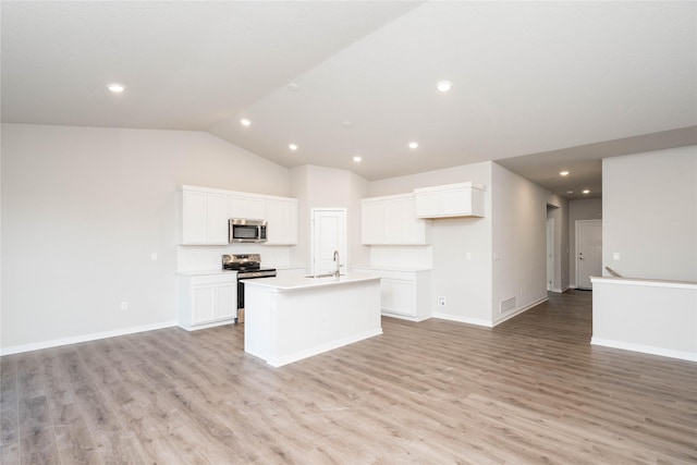 kitchen with sink, an island with sink, light hardwood / wood-style floors, white cabinetry, and stainless steel appliances