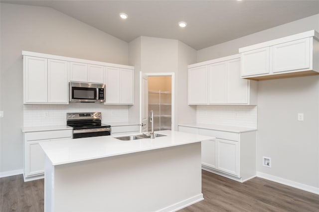 kitchen with backsplash, sink, stainless steel appliances, and a center island with sink