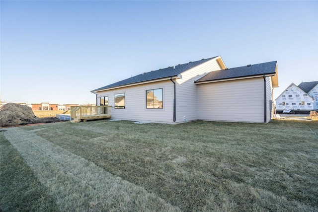 rear view of property with a deck and a yard