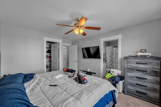 carpeted bedroom featuring ceiling fan and ensuite bath