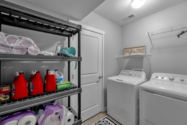 laundry area with a textured ceiling and independent washer and dryer