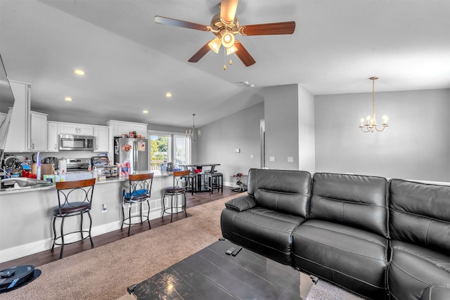 living room featuring ceiling fan with notable chandelier, lofted ceiling, and dark hardwood / wood-style floors