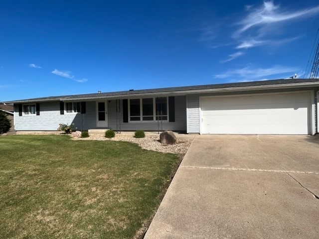 ranch-style house featuring a garage and a front yard