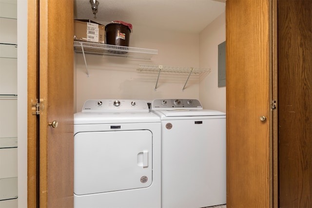 laundry room with electric panel and washing machine and clothes dryer