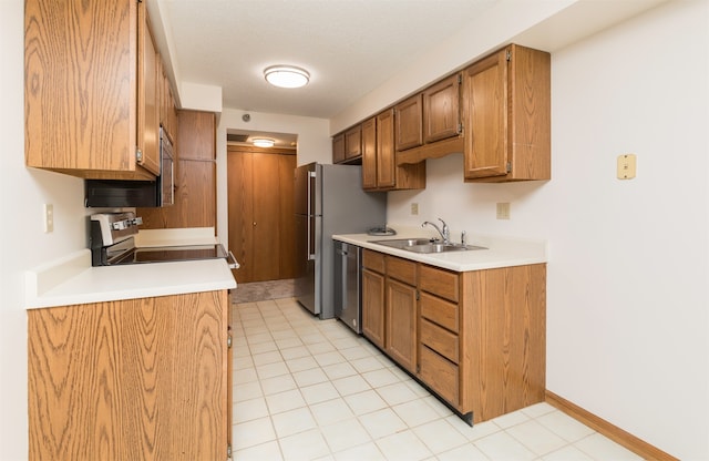 kitchen with light tile patterned flooring, a textured ceiling, stove, stainless steel dishwasher, and sink