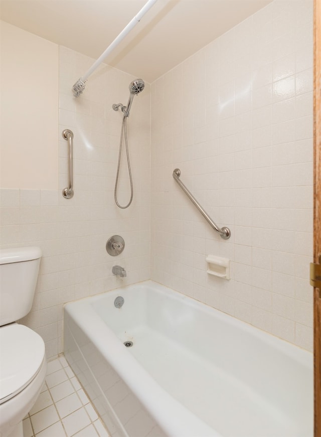 bathroom with tiled shower / bath, tile walls, toilet, and tile patterned floors