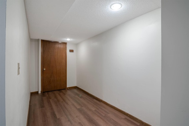 hallway featuring wood-type flooring and a textured ceiling