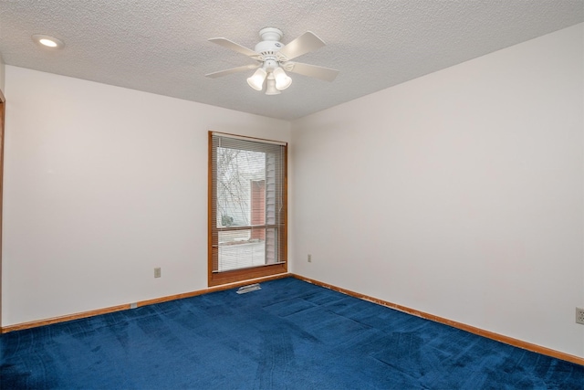 empty room with ceiling fan, carpet, and a textured ceiling