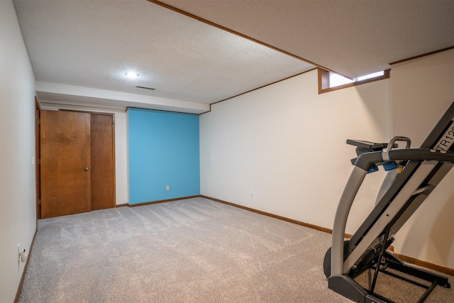 workout area featuring light colored carpet and a textured ceiling