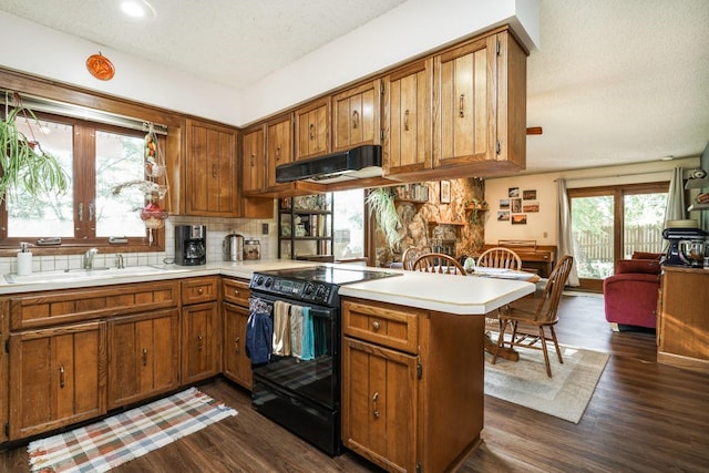 kitchen featuring sink, dark wood-type flooring, tasteful backsplash, black electric range, and kitchen peninsula