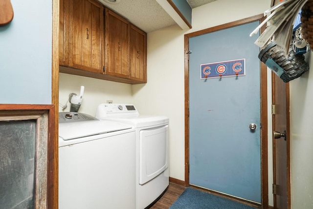 laundry room featuring cabinets, dark hardwood / wood-style flooring, and washing machine and dryer