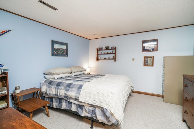 bedroom with ornamental molding and light carpet