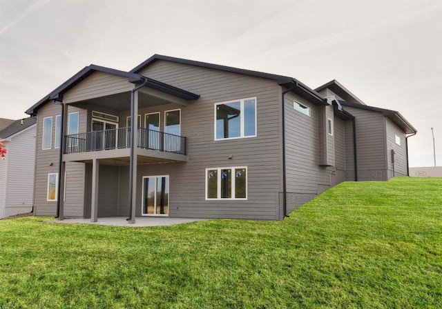 back of house with a yard, a balcony, and a patio