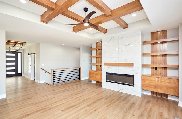 unfurnished living room with beamed ceiling, light hardwood / wood-style flooring, a tile fireplace, and coffered ceiling