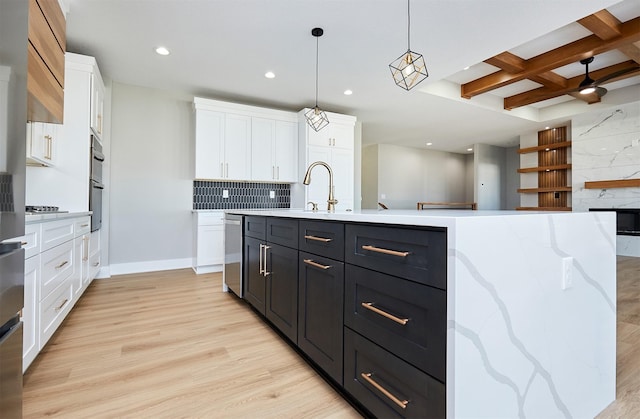 kitchen featuring beam ceiling, white cabinetry, hanging light fixtures, coffered ceiling, and a kitchen island with sink