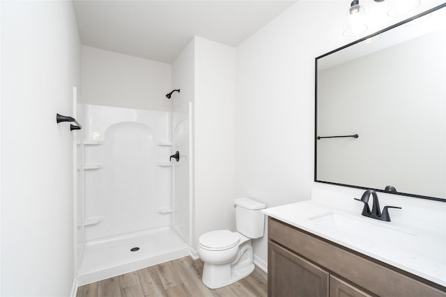 bathroom featuring walk in shower, toilet, vanity, and hardwood / wood-style flooring