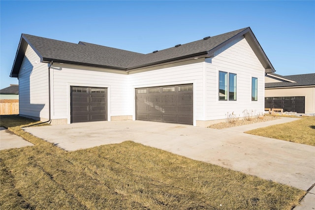 view of side of home with a garage and a lawn