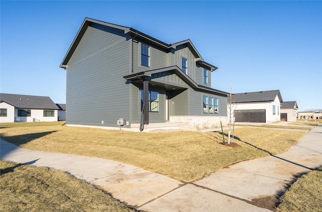 view of front of home with a garage, an outdoor structure, and a front yard