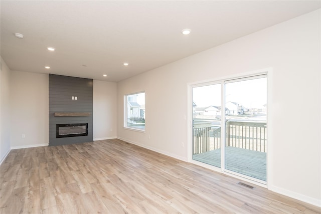 unfurnished living room with a fireplace and light hardwood / wood-style flooring