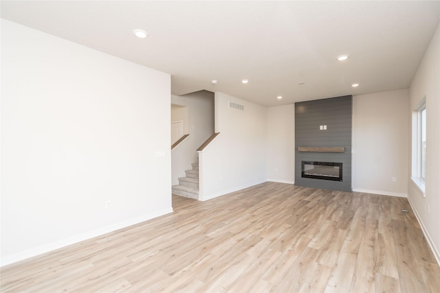 unfurnished living room featuring light hardwood / wood-style floors and a fireplace