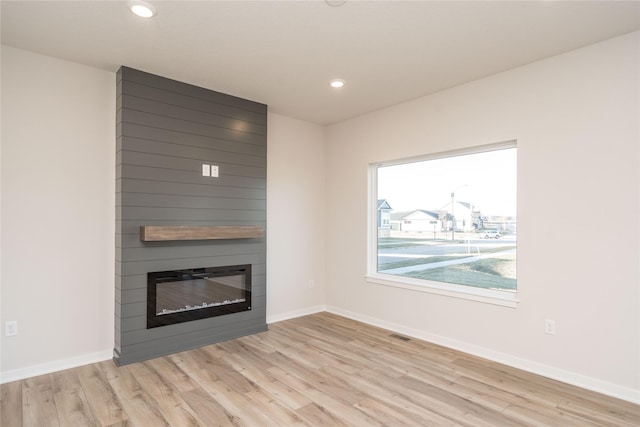 unfurnished living room featuring a fireplace and light wood-type flooring