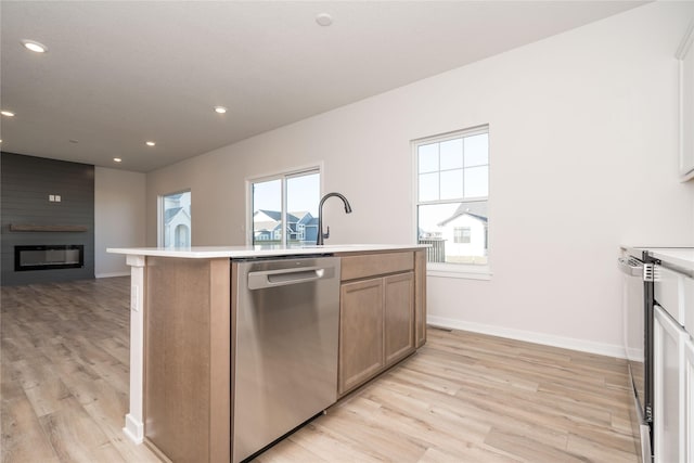 kitchen with a kitchen island with sink, range with electric cooktop, stainless steel dishwasher, light wood-type flooring, and a fireplace