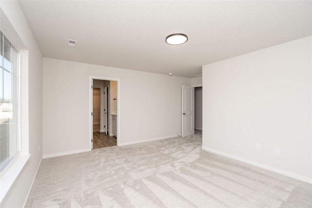 carpeted empty room with a textured ceiling