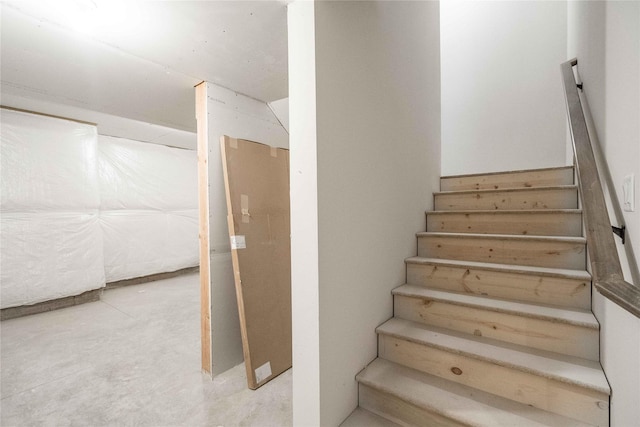 staircase featuring concrete floors