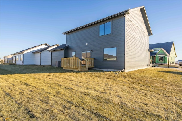 back of house with a yard, a wooden deck, and central AC