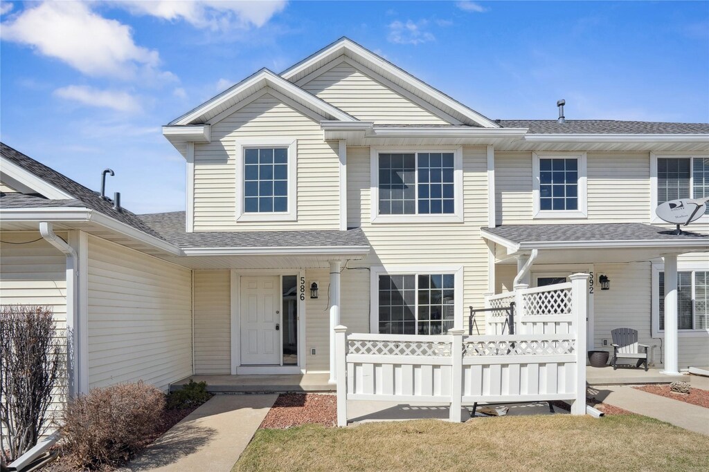 multi unit property featuring a porch and a shingled roof