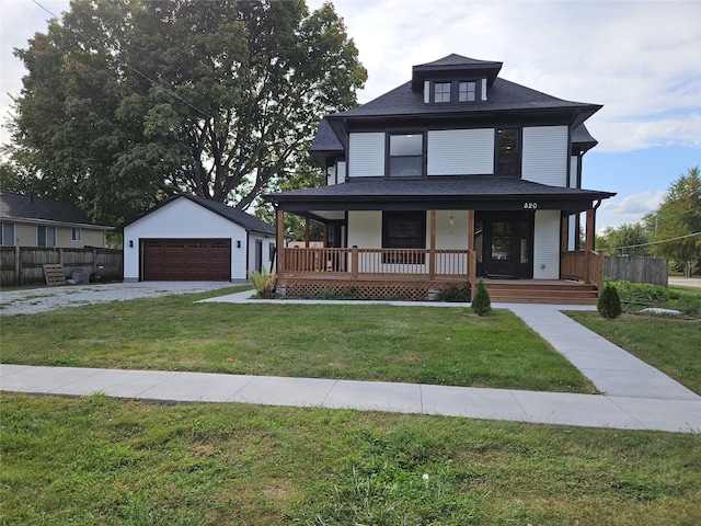 view of front facade with covered porch, a garage, an outbuilding, and a front yard