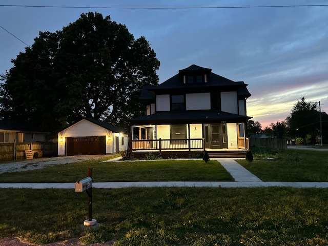 view of front of property featuring a yard, an outbuilding, a porch, and a garage