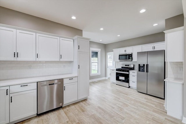 kitchen featuring light hardwood / wood-style floors, white cabinetry, appliances with stainless steel finishes, and tasteful backsplash