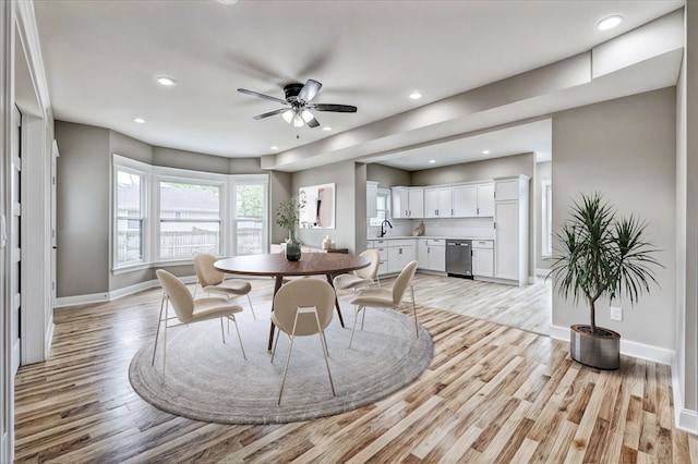 dining space with ceiling fan, sink, and light hardwood / wood-style floors