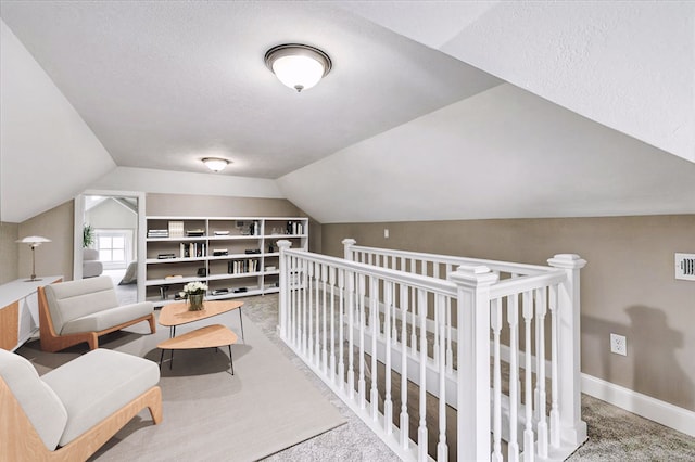 interior space featuring a textured ceiling, carpet, and vaulted ceiling