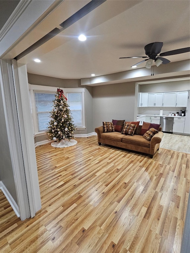 living room featuring ceiling fan and light hardwood / wood-style flooring