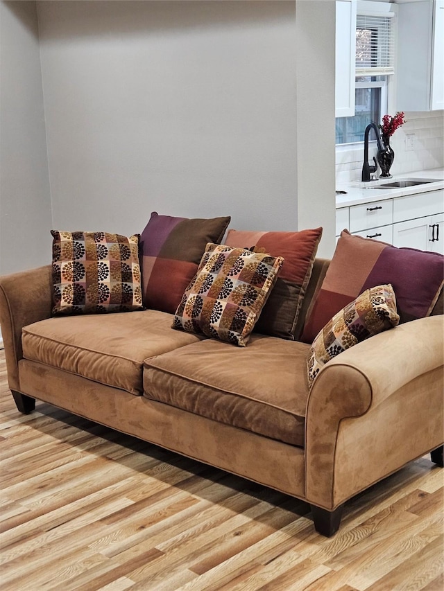 living room featuring sink and light hardwood / wood-style flooring