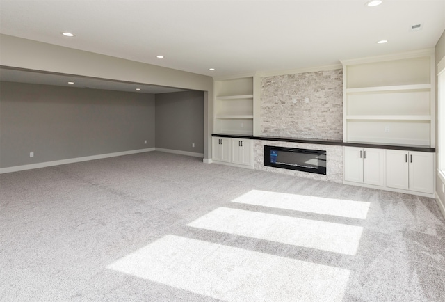 unfurnished living room featuring light carpet, a fireplace, and built in features