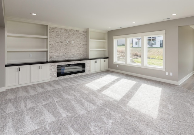 unfurnished living room with light colored carpet and built in shelves