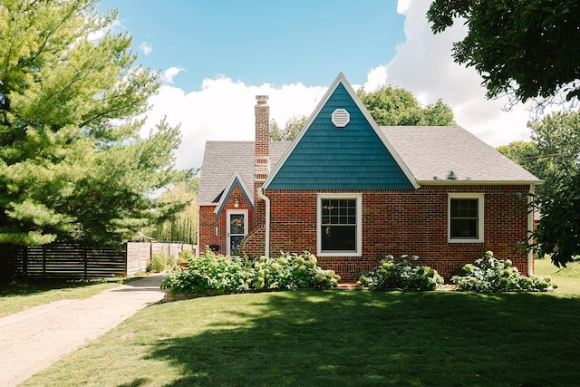 english style home featuring a front yard